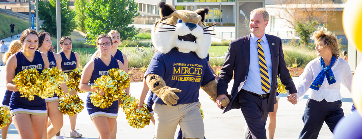 UC Merced - Interim Chancellor Brostrom and Rufus Bobcat walk students across campus